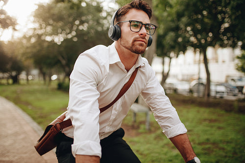 Man going to office on a bicycle listening to music