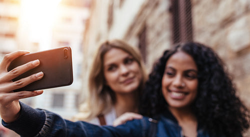 Two women posing for a selfie outdoors