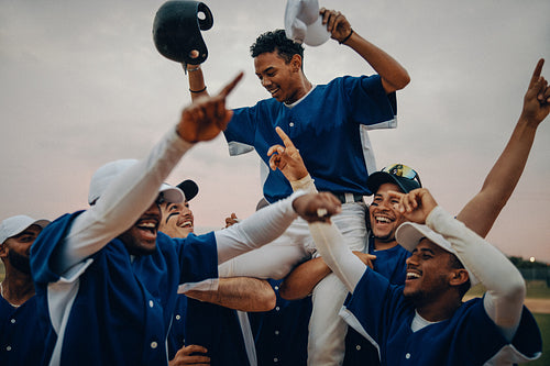 Baseball team celebrates victory with passion and dedication under the evening sky