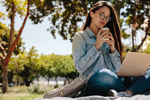 College girl sitting in campus using a laptop