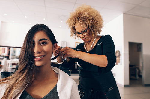 Female hair stylist working on a woman 's hair at salon