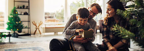Christmas holiday moments - a boy with his family having a look at his Christmas gift