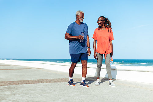 Couple enjoying a sunny walk on the beach promenade