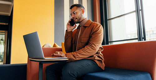 Businessman taking a phone call in an office lobby