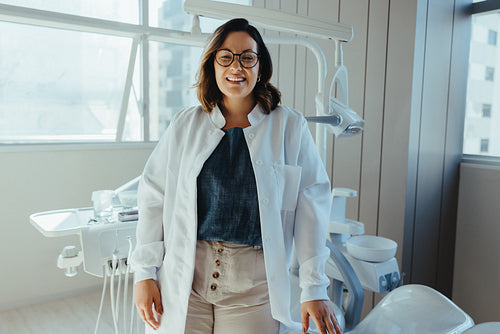 Woman dentist smiling in the clinic with a professional and friendly presence