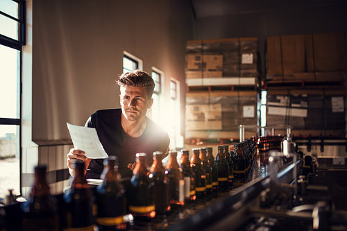 Worker checking the process on the production line in brewery factory