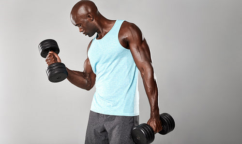 African fitness model working out with dumbbells
