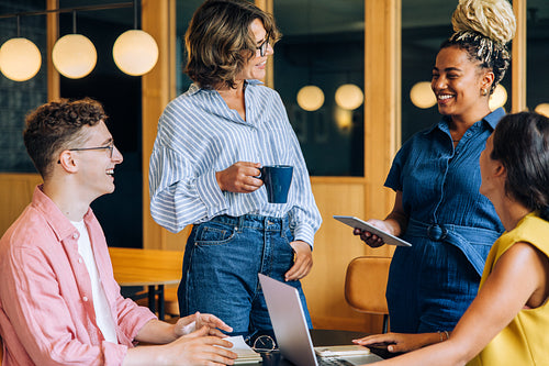 Group of young adults casually discussing ideas in a modern office space