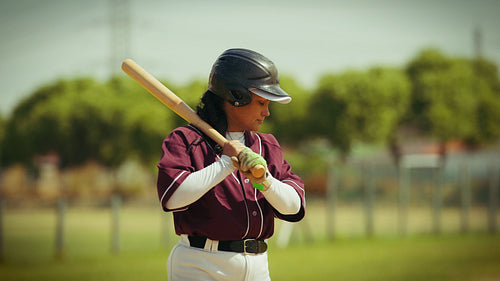 Female player takes a practice swing on the baseball field