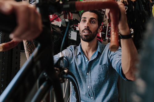 Worker inspecting a bicycle in workshop