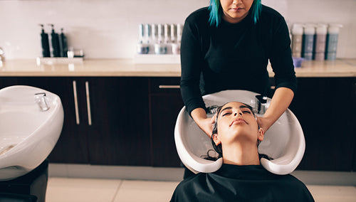 Woman getting hair wash done at salon