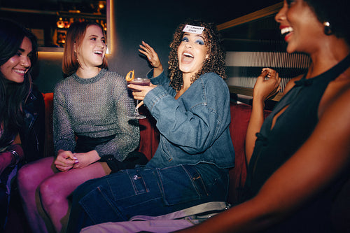 Group of friends enjoying a fun game night with drinks and laughter