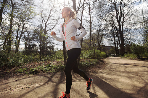 Fit female model jogging in forest