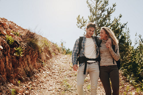 Couple walking down the mountain trail 