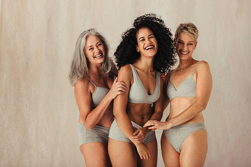 Smiling women of different ages embracing their natural bodies