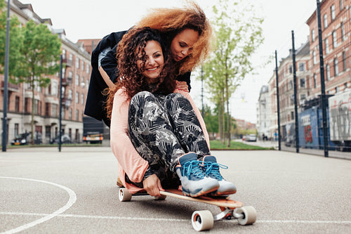 Young woman skating together on a longboard