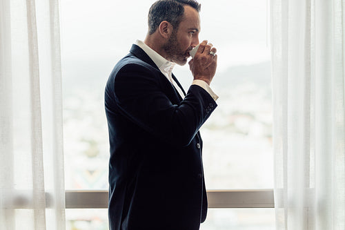 Business traveler in hotel room having coffee