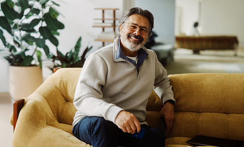 Senior man holds a credit card for online shopping at home