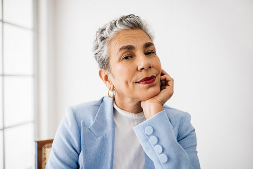Confident senior business woman sitting in her office in an elegant business attire