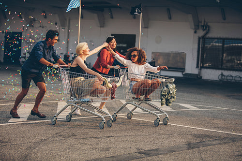 Young friends racing with shopping carts