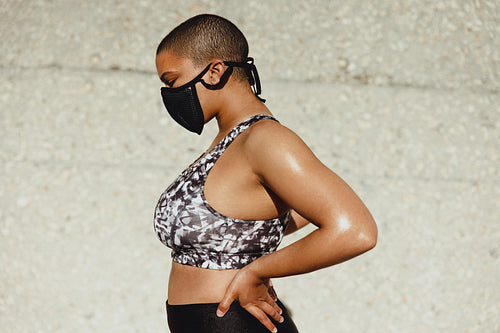 Woman with muscular and healthy body wearing face mask