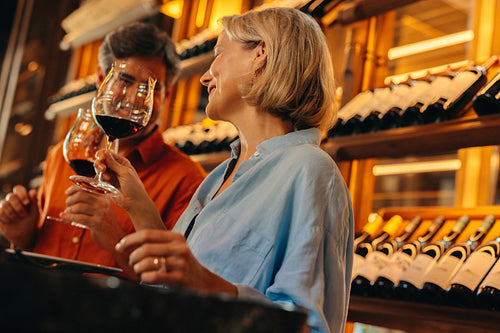 Woman sitting and talking while holding a glass of wine at a bar