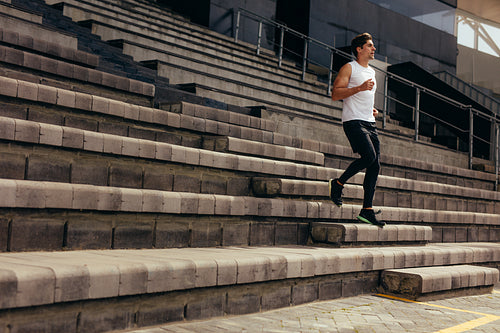 Athlete running down the stairs of a stadium stand