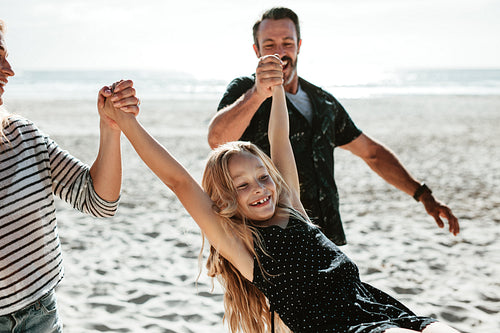 Girl enjoying vacation on beach with her parents