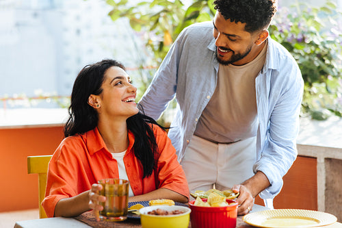 Happy couple sharing a meal and enjoying time on a sunny patio