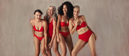 Four women of all ages having fun in red swimwear