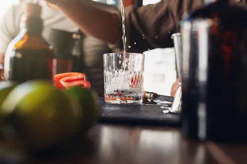 Bartender pouring drink into a glass