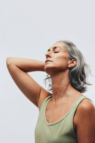 Woman with closed eyes stretching neck in studio