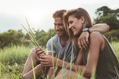 Smiling young couple sitting together outdoor