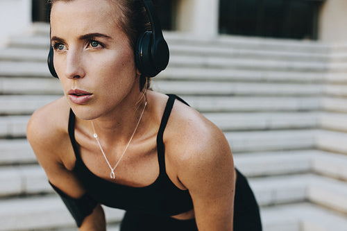 Woman training outdoors relaxing with hands on knees