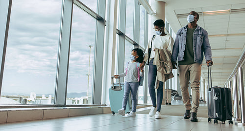 Family walking through airport passageway