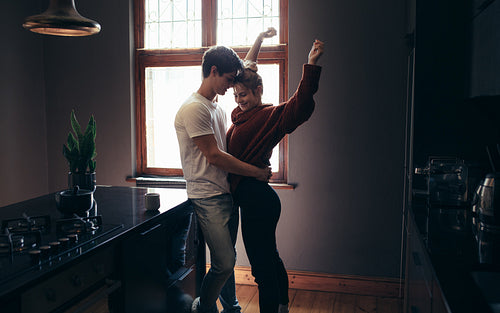 Affectionate couple standing together in the kitchen