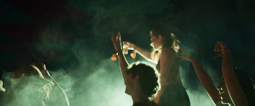 Friends dancing and cheering together at a music festival