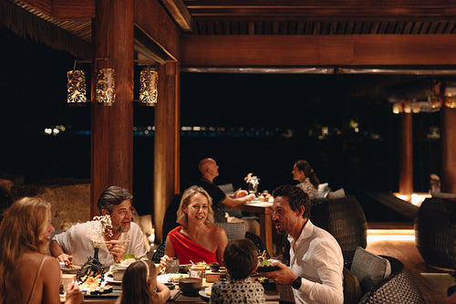 Happy family enjoying a fine dining experience at a coastal resort