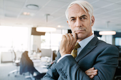 Thoughtful mature businessman staring at camera