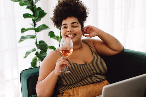 Woman sitting on sofa having wine at home