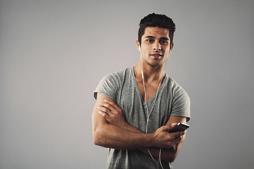 Casual young man listening music on mobile phone