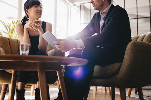 Businesspeople using digital tablet in office lobby