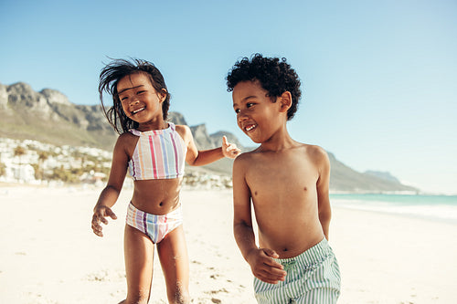 Happy young kids playing around at the beach