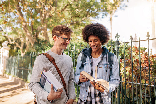 Students with books walking outside on the road