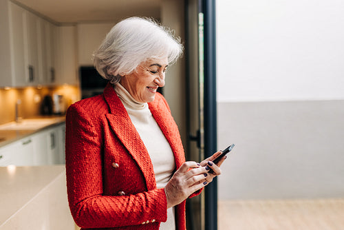 Mature businesswoman using a smartphone at home