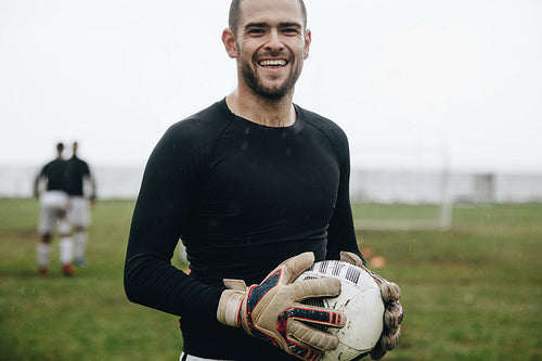 Close up of a smiling soccer player standing on field