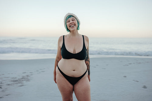 Carefree winter bather smiling with her eyes closed at the beach
