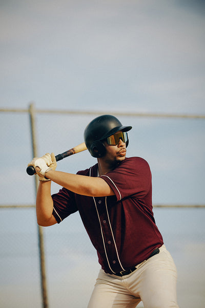Baseball player at bat poised for action during a sunny game day on the field