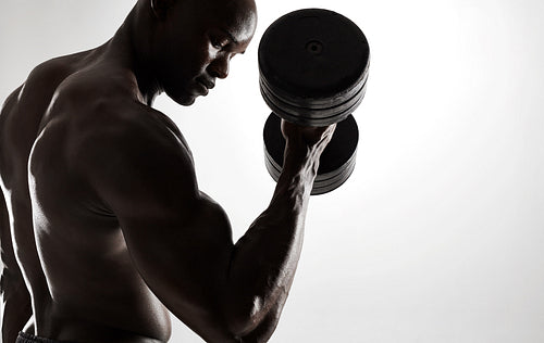 Young african man working out with dumbbells