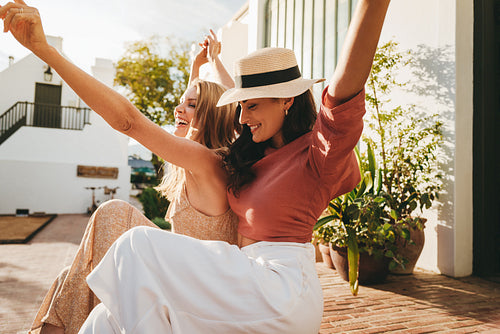 Girlfriends dancing cheerfully during their vacation
